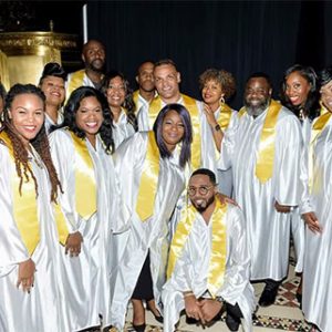 East Coast Inspirational Singers gospel choir in white robes with gold stoles performing at Locktown Stone Church.