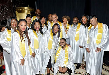 East Coast Inspirational Singers gospel choir in white robes with gold stoles performing at Locktown Stone Church.