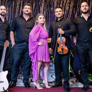 Paganini Brazilian Band posing with violin, saxophone, guitar, and band members at Locktown Stone Church.