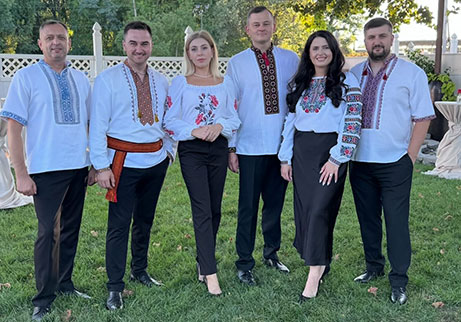 Soloway Band members standing outdoors in embroidered traditional attire before performing at Locktown Stone Church.